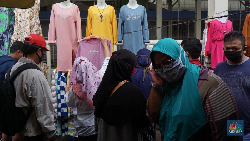 Warga memadati kawasan pedagang kaki lima di Pasar Tanah Abang saat penerapan pembatasan sosial berskala besar (PSBB) di Jakarta, Senin (18/5/2020). Meski pertokoan di Pasar Tanah Abang tutup karena PSBB, menjelang hari lebaran kawasan tersebut dipadati pedagang kaki lima yang berada di gang-gang dekat pasar. CNBC Indonesia/Tri Susilo.   


Memasuki H-7 lebaran Idul Fitri, Pasar Tanah Abang kembali ramai dipadati masyarakat meskipun pemerintah Provinsi DKI Jakarta masih menutup pasar tersebut sejak 27 Maret karena diberlakukanPembatasan Sosial Bersekala Besar (PSBB) untuk mengatasi penyebaran Covid-19.

Keramaian terlihat disejumlah titik seperti sebrang Blok F dan depan stasiun Tanah Abang, jalanan tersebut dipadati pedagang kaki lima dan warga tanpa mematuhi peraturan jaga jarak sesuai dengan himbauan pemerintah.
Para pedagang nekat turun kepinggir jalan karena sejak kios mereka ditutup, para pedagang tidak mendapatkan penghasilan, padahal biasanya menjelang lebaran mereka bisa meraup untung besar. (CNBC Indonesia/Tri Susilo.)