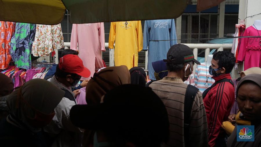 Warga memadati kawasan pedagang kaki lima di Pasar Tanah Abang saat penerapan pembatasan sosial berskala besar (PSBB) di Jakarta, Senin (18/5/2020). Meski pertokoan di Pasar Tanah Abang tutup karena PSBB, menjelang hari lebaran kawasan tersebut dipadati pedagang kaki lima yang berada di gang-gang dekat pasar. CNBC Indonesia/Tri Susilo.   


Memasuki H-7 lebaran Idul Fitri, Pasar Tanah Abang kembali ramai dipadati masyarakat meskipun pemerintah Provinsi DKI Jakarta masih menutup pasar tersebut sejak 27 Maret karena diberlakukanPembatasan Sosial Bersekala Besar (PSBB) untuk mengatasi penyebaran Covid-19.

Keramaian terlihat disejumlah titik seperti sebrang Blok F dan depan stasiun Tanah Abang, jalanan tersebut dipadati pedagang kaki lima dan warga tanpa mematuhi peraturan jaga jarak sesuai dengan himbauan pemerintah.
Para pedagang nekat turun kepinggir jalan karena sejak kios mereka ditutup, para pedagang tidak mendapatkan penghasilan, padahal biasanya menjelang lebaran mereka bisa meraup untung besar. (CNBC Indonesia/Tri Susilo.)