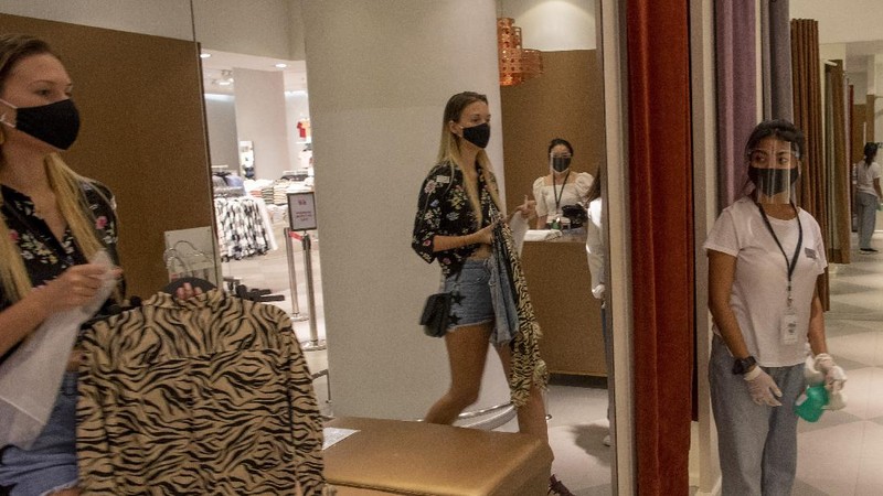 Patrons stand maintaining a physical distance at the entrance of the upmarket shopping mall Siam Paragon in Bangkok, Thailand, Sunday, May 17, 2020. Thai authorities allowed department stores, shopping malls and other businesses to reopen from Sunday, selectively easing restrictions meant to combat the coronavirus. (AP Photo/ Gemunu Amarasinghe)