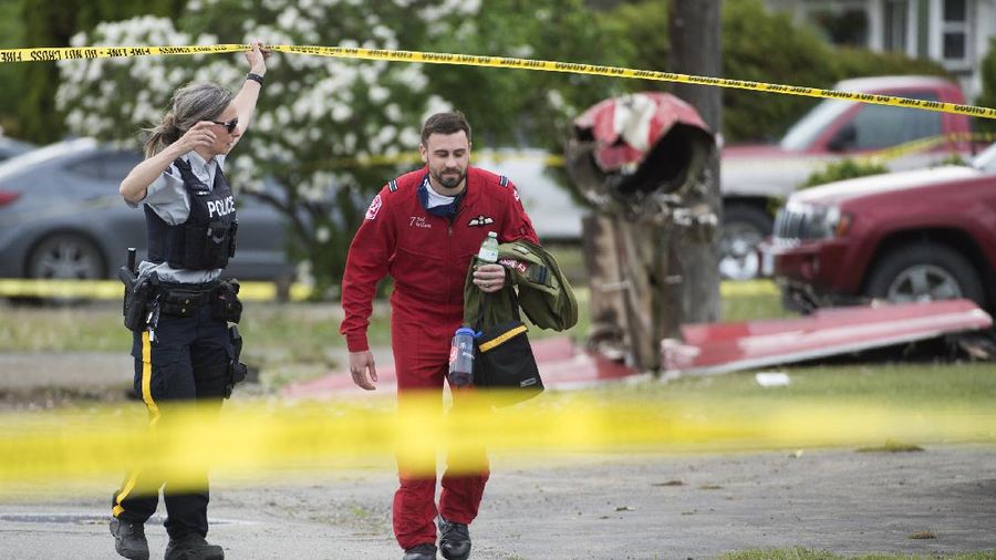 First responders attend to a person on a rooftop at the scene of a crash involving a Canadian Forces Snowbirds airplane in Kamloops, British Columbia, Sunday, May 17, 2020. (Brendan Kergin/Castanet Kamloops/The Canadian Press via AP)