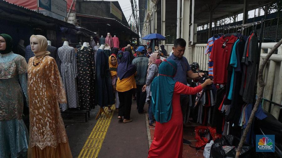 Warga memadati kawasan pedagang kaki lima di Pasar Tanah Abang saat penerapan pembatasan sosial berskala besar (PSBB) di Jakarta, Senin (18/5/2020). Meski pertokoan di Pasar Tanah Abang tutup karena PSBB, menjelang hari lebaran kawasan tersebut dipadati pedagang kaki lima yang berada di gang-gang dekat pasar. CNBC Indonesia/Tri Susilo.   


Memasuki H-7 lebaran Idul Fitri, Pasar Tanah Abang kembali ramai dipadati masyarakat meskipun pemerintah Provinsi DKI Jakarta masih menutup pasar tersebut sejak 27 Maret karena diberlakukanPembatasan Sosial Bersekala Besar (PSBB) untuk mengatasi penyebaran Covid-19.

Keramaian terlihat disejumlah titik seperti sebrang Blok F dan depan stasiun Tanah Abang, jalanan tersebut dipadati pedagang kaki lima dan warga tanpa mematuhi peraturan jaga jarak sesuai dengan himbauan pemerintah.
Para pedagang nekat turun kepinggir jalan karena sejak kios mereka ditutup, para pedagang tidak mendapatkan penghasilan, padahal biasanya menjelang lebaran mereka bisa meraup untung besar. (CNBC Indonesia/Tri Susilo.)