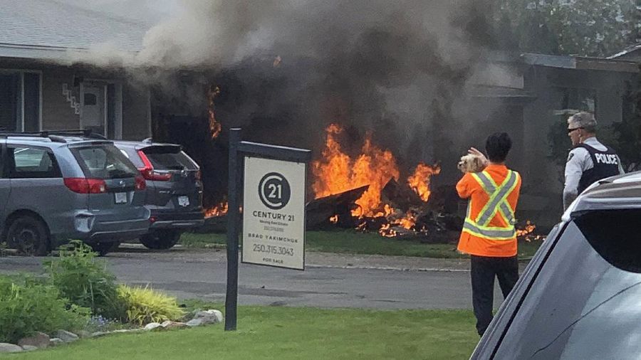 First responders attend to a person on a rooftop at the scene of a crash involving a Canadian Forces Snowbirds airplane in Kamloops, British Columbia, Sunday, May 17, 2020. (Brendan Kergin/Castanet Kamloops/The Canadian Press via AP)