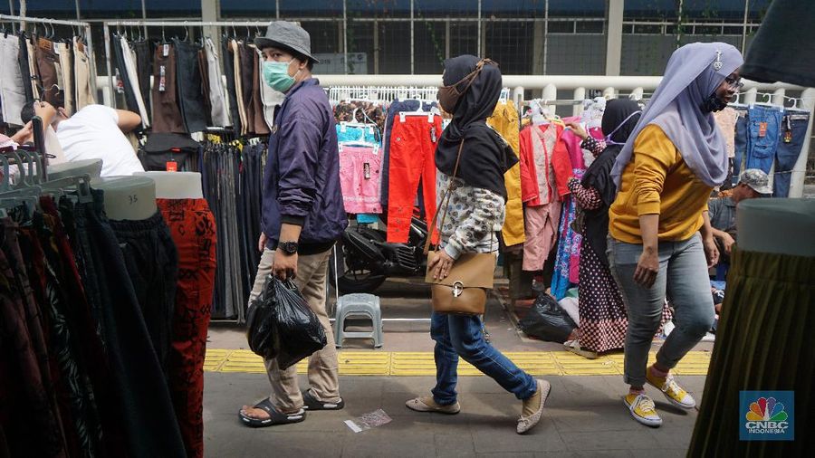 Warga memadati kawasan pedagang kaki lima di Pasar Tanah Abang saat penerapan pembatasan sosial berskala besar (PSBB) di Jakarta, Senin (18/5/2020). Meski pertokoan di Pasar Tanah Abang tutup karena PSBB, menjelang hari lebaran kawasan tersebut dipadati pedagang kaki lima yang berada di gang-gang dekat pasar. CNBC Indonesia/Tri Susilo.   


Memasuki H-7 lebaran Idul Fitri, Pasar Tanah Abang kembali ramai dipadati masyarakat meskipun pemerintah Provinsi DKI Jakarta masih menutup pasar tersebut sejak 27 Maret karena diberlakukanPembatasan Sosial Bersekala Besar (PSBB) untuk mengatasi penyebaran Covid-19.

Keramaian terlihat disejumlah titik seperti sebrang Blok F dan depan stasiun Tanah Abang, jalanan tersebut dipadati pedagang kaki lima dan warga tanpa mematuhi peraturan jaga jarak sesuai dengan himbauan pemerintah.
Para pedagang nekat turun kepinggir jalan karena sejak kios mereka ditutup, para pedagang tidak mendapatkan penghasilan, padahal biasanya menjelang lebaran mereka bisa meraup untung besar. (CNBC Indonesia/Tri Susilo.)
