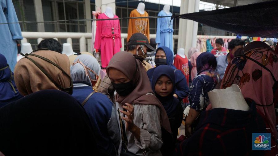 Warga memadati kawasan pedagang kaki lima di Pasar Tanah Abang saat penerapan pembatasan sosial berskala besar (PSBB) di Jakarta, Senin (18/5/2020). Meski pertokoan di Pasar Tanah Abang tutup karena PSBB, menjelang hari lebaran kawasan tersebut dipadati pedagang kaki lima yang berada di gang-gang dekat pasar. CNBC Indonesia/Tri Susilo.   


Memasuki H-7 lebaran Idul Fitri, Pasar Tanah Abang kembali ramai dipadati masyarakat meskipun pemerintah Provinsi DKI Jakarta masih menutup pasar tersebut sejak 27 Maret karena diberlakukanPembatasan Sosial Bersekala Besar (PSBB) untuk mengatasi penyebaran Covid-19.

Keramaian terlihat disejumlah titik seperti sebrang Blok F dan depan stasiun Tanah Abang, jalanan tersebut dipadati pedagang kaki lima dan warga tanpa mematuhi peraturan jaga jarak sesuai dengan himbauan pemerintah.
Para pedagang nekat turun kepinggir jalan karena sejak kios mereka ditutup, para pedagang tidak mendapatkan penghasilan, padahal biasanya menjelang lebaran mereka bisa meraup untung besar. (CNBC Indonesia/Tri Susilo.)