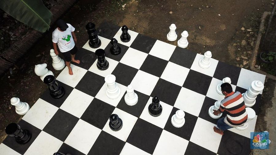 Warga bermain catur raksasa di Pondok Betung, Tangerang Selatan, Banten, Indonesia, Selasa (19/5/2020). Hal itu guna mengisi kegiatan jelang berbuka puasa sekaligus berolahraga di tengah pandemi COVID-19. (CNBC Indonesia/ Andrean Kristianto)