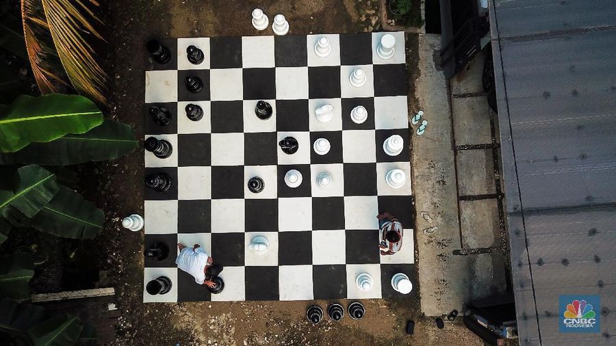 Warga bermain catur raksasa di Pondok Betung, Tangerang Selatan, Banten, Indonesia, Selasa (19/5/2020). Hal itu guna mengisi kegiatan jelang berbuka puasa sekaligus berolahraga di tengah pandemi COVID-19. (CNBC Indonesia/ Andrean Kristianto)