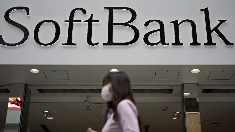 In this Oct. 8, 2019 photo, a person walks by a SoftBank shop in Tokyo. Japanese technology company SoftBank Group Corp. racked up a loss of 961.6 billion yen ($9 billion) for the fiscal year through March, on red ink related to its Vision Fund investments, including troubled office space-sharing venture WeWork. (AP Photo/Eugene Hoshiko)