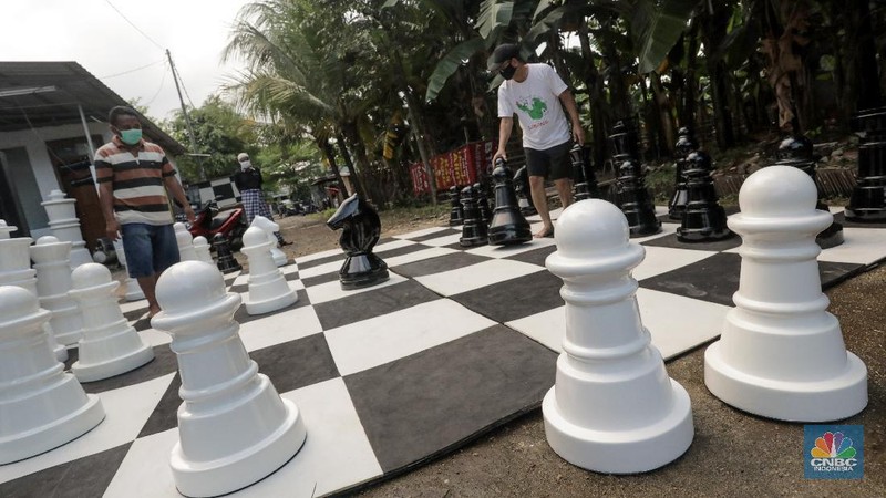 Warga bermain catur raksasa di Pondok Betung, Tangerang Selatan, Banten, Indonesia, Selasa (19/5/2020). Hal itu guna mengisi kegiatan jelang berbuka puasa sekaligus berolahraga di tengah pandemi COVID-19. (CNBC Indonesia/ Andrean Kristianto)