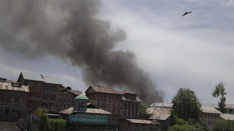 Kashmiri men cover their faces in response to the pellets fired by Indian police during a protest near the site of a gun battle in Srinagar, Indian controlled Kashmir, Tuesday, May 19, 2020. Indian government forces killed two rebels in disputed Kashmir on Tuesday and shut down cellphone and mobile internet services during subsequent anti-India protests, officials and residents said. (AP Photo/ Dar Yasin)