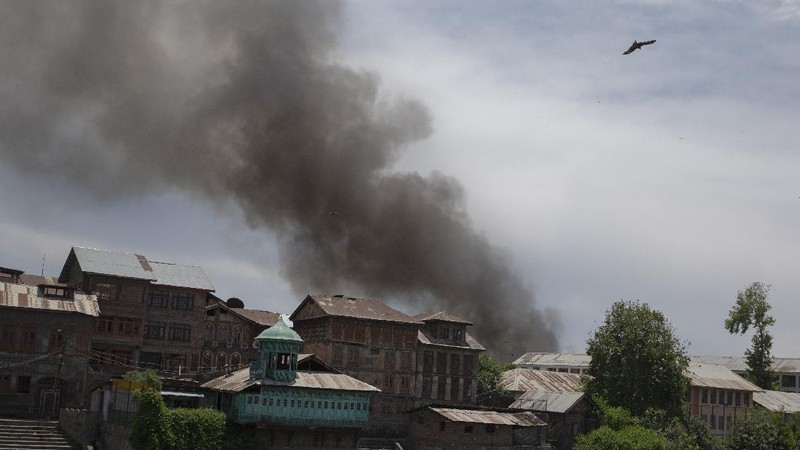 Kashmiri men cover their faces in response to the pellets fired by Indian police during a protest near the site of a gun battle in Srinagar, Indian controlled Kashmir, Tuesday, May 19, 2020. Indian government forces killed two rebels in disputed Kashmir on Tuesday and shut down cellphone and mobile internet services during subsequent anti-India protests, officials and residents said. (AP Photo/ Dar Yasin)