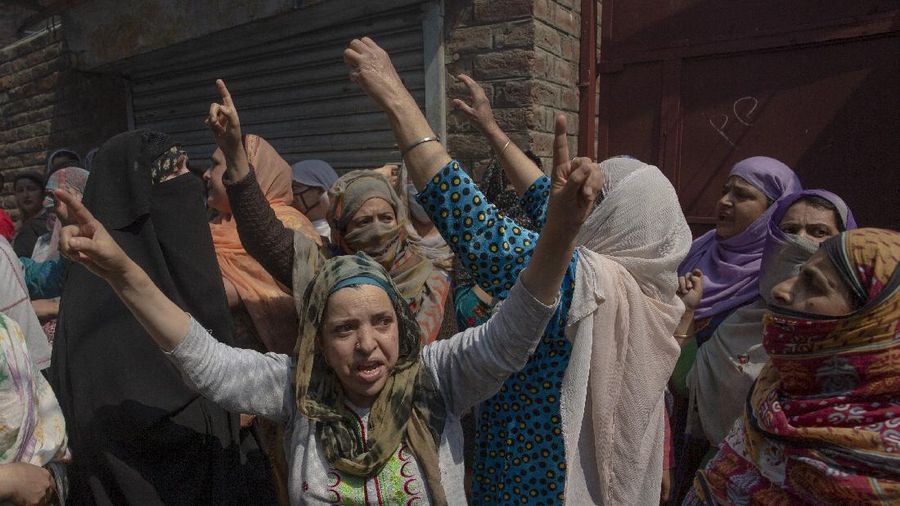 Kashmiri men cover their faces in response to the pellets fired by Indian police during a protest near the site of a gun battle in Srinagar, Indian controlled Kashmir, Tuesday, May 19, 2020. Indian government forces killed two rebels in disputed Kashmir on Tuesday and shut down cellphone and mobile internet services during subsequent anti-India protests, officials and residents said. (AP Photo/ Dar Yasin)