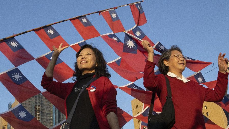 In this photo taken Thursday, Jan. 9, 2020, supporters of the Nationalist or KMT party pose with the Taiwanese flag during a rally for the presidential election in Taipei, Taiwan. About two-thirds of Taiwanese don't identify as Chinese, according to a survey released Tuesday, highlighting the challenge China faces to bringing the self-governing island under its control. The U.S.-based Pew Research Center found that 66 percent view themselves as Taiwanese, 28 percent as both Taiwanese and Chinese and 4 percent as just Chinese. (AP Photo/Ng Han Guan)