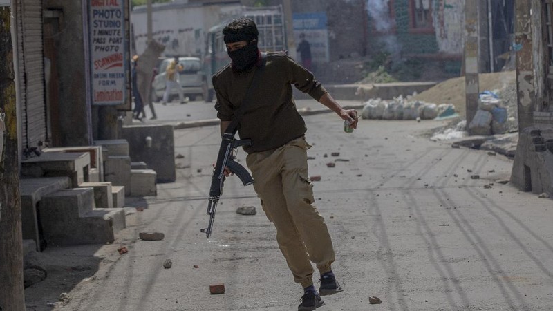Kashmiri men cover their faces in response to the pellets fired by Indian police during a protest near the site of a gun battle in Srinagar, Indian controlled Kashmir, Tuesday, May 19, 2020. Indian government forces killed two rebels in disputed Kashmir on Tuesday and shut down cellphone and mobile internet services during subsequent anti-India protests, officials and residents said. (AP Photo/ Dar Yasin)