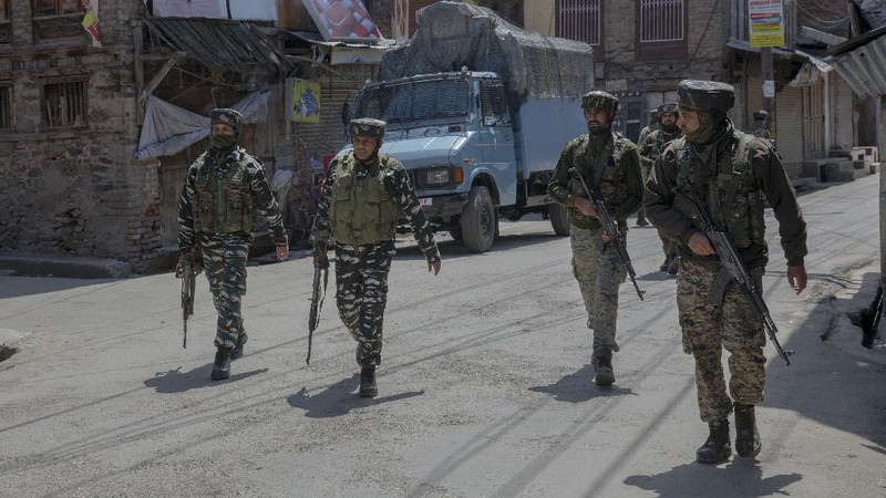 Kashmiri men cover their faces in response to the pellets fired by Indian police during a protest near the site of a gun battle in Srinagar, Indian controlled Kashmir, Tuesday, May 19, 2020. Indian government forces killed two rebels in disputed Kashmir on Tuesday and shut down cellphone and mobile internet services during subsequent anti-India protests, officials and residents said. (AP Photo/ Dar Yasin)