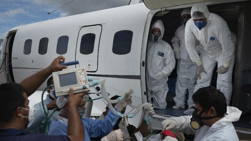 Health workers prepare to move 89-year-old COVID-19 patient Sildomar Castelo Branco into an aircraft as he is transferred from Santo Antonio do Içá to a hospital in Manaus, Brazil, Tuesday, May 19, 2020. (AP Photo/Felipe Dana)