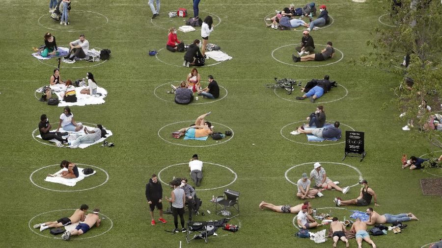 Jaga jarak saat berjemur di taman New York. AP/Kathy Willens
