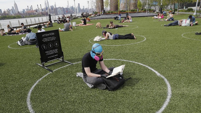Jaga jarak saat berjemur di taman New York. AP/Kathy Willens