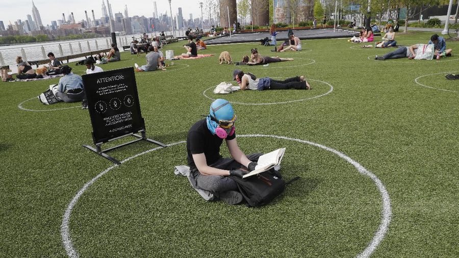 Jaga jarak saat berjemur di taman New York. AP/Kathy Willens