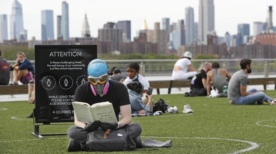 Jaga jarak saat berjemur di taman New York. AP/Kathy Willens