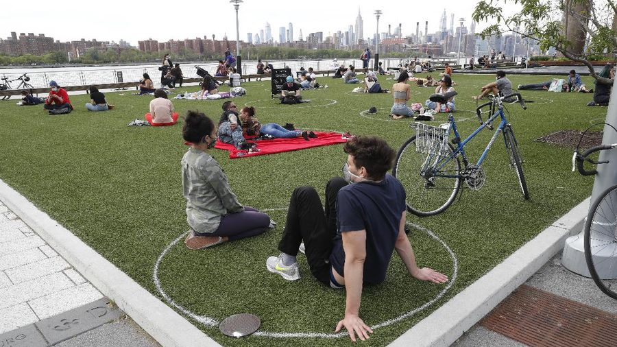 Jaga jarak saat berjemur di taman New York. AP/Kathy Willens