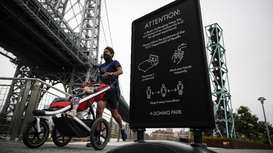 Jaga jarak saat berjemur di taman New York. AP/Kathy Willens