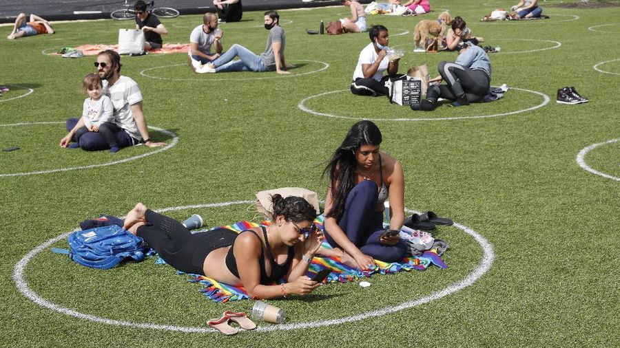 Jaga jarak saat berjemur di taman New York. AP/Kathy Willens