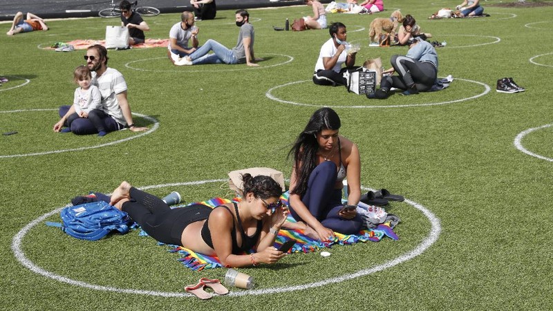 Jaga jarak saat berjemur di taman New York. AP/Kathy Willens