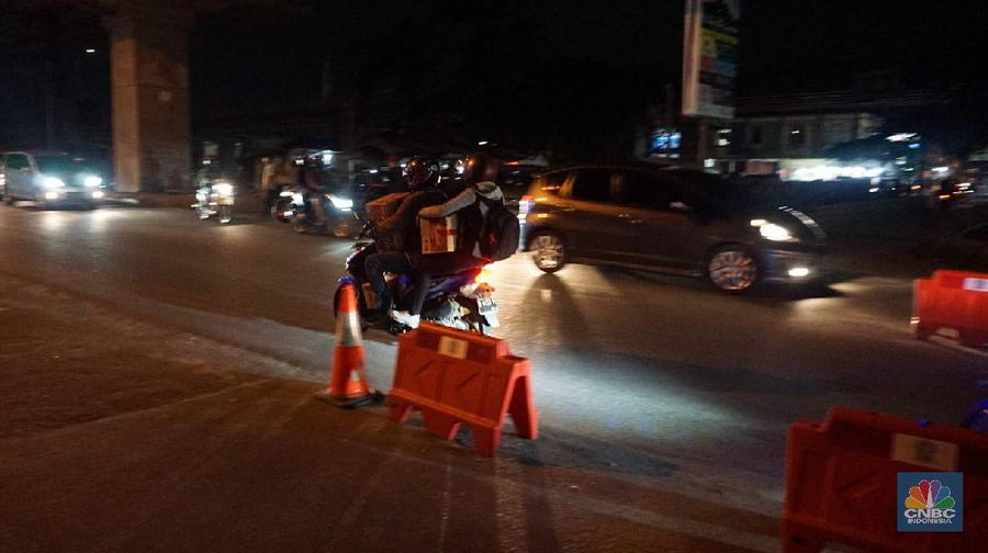 Petugas memeriksa kendaraan roda dua yang diduga untuk berpergian mudik di Jalan Raya Kalimalang, Jakarta Timur, Jumat (22/5). Dua hari jelang lebaran para pengendara motor masih ada yang nekat untuk pergi mudik. Petugas kepolisian dan Dishub memberhentikan motor yang memiliki muatan lebih. Pengendara motor diperiksa juga KTP asalnya. Jika ketahuan dari mereka mudik petugas menyuruh para pemudik motor untuk putar balik. Petugas kepolisian yang berjaga di check point jalan raya Kalimalang ini terus memantau, mengawasi dan melakukan pemeriksaan secara ketat agar pemudik yang berusaha keluar dari Jakarta bisa dihalau. Seperti diketahui Pengendara yang melintas masuk atau keluar ibu kota di 12 titik checkpoint, wajib menunjukkan SIKM. Ketentuan ini sesuai Peraturan Gubernur Nomor 47 Tahun 2020 tentang Pembatasan Berpergian Keluar Masuk DKI Jakarta. SIKM diperuntukan bagi warga yang karena tugas dan pekerjaannya harus melakukan perjalanan dinas keluar dan/atau masuk wilayah DKI Jakarta atau Jabodetabek selama masa pandemi.  (CNBC Indonesia/ Muhammad Sabki)