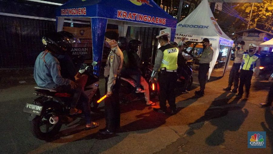 Petugas memeriksa kendaraan roda dua yang diduga untuk berpergian mudik di Jalan Raya Kalimalang, Jakarta Timur, Jumat (22/5). Dua hari jelang lebaran para pengendara motor masih ada yang nekat untuk pergi mudik. Petugas kepolisian dan Dishub memberhentikan motor yang memiliki muatan lebih. Pengendara motor diperiksa juga KTP asalnya. Jika ketahuan dari mereka mudik petugas menyuruh para pemudik motor untuk putar balik. Petugas kepolisian yang berjaga di check point jalan raya Kalimalang ini terus memantau, mengawasi dan melakukan pemeriksaan secara ketat agar pemudik yang berusaha keluar dari Jakarta bisa dihalau. Seperti diketahui Pengendara yang melintas masuk atau keluar ibu kota di 12 titik checkpoint, wajib menunjukkan SIKM. Ketentuan ini sesuai Peraturan Gubernur Nomor 47 Tahun 2020 tentang Pembatasan Berpergian Keluar Masuk DKI Jakarta. SIKM diperuntukan bagi warga yang karena tugas dan pekerjaannya harus melakukan perjalanan dinas keluar dan/atau masuk wilayah DKI Jakarta atau Jabodetabek selama masa pandemi.  (CNBC Indonesia/ Muhammad Sabki)