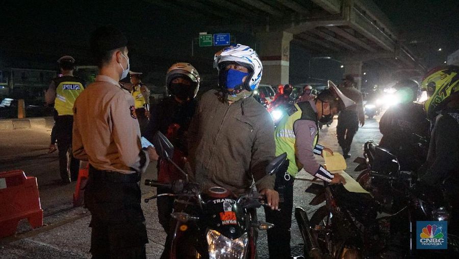 Petugas memeriksa kendaraan roda dua yang diduga untuk berpergian mudik di Jalan Raya Kalimalang, Jakarta Timur, Jumat (22/5). Dua hari jelang lebaran para pengendara motor masih ada yang nekat untuk pergi mudik. Petugas kepolisian dan Dishub memberhentikan motor yang memiliki muatan lebih. Pengendara motor diperiksa juga KTP asalnya. Jika ketahuan dari mereka mudik petugas menyuruh para pemudik motor untuk putar balik. Petugas kepolisian yang berjaga di check point jalan raya Kalimalang ini terus memantau, mengawasi dan melakukan pemeriksaan secara ketat agar pemudik yang berusaha keluar dari Jakarta bisa dihalau. Seperti diketahui Pengendara yang melintas masuk atau keluar ibu kota di 12 titik checkpoint, wajib menunjukkan SIKM. Ketentuan ini sesuai Peraturan Gubernur Nomor 47 Tahun 2020 tentang Pembatasan Berpergian Keluar Masuk DKI Jakarta. SIKM diperuntukan bagi warga yang karena tugas dan pekerjaannya harus melakukan perjalanan dinas keluar dan/atau masuk wilayah DKI Jakarta atau Jabodetabek selama masa pandemi.  (CNBC Indonesia/ Muhammad Sabki)