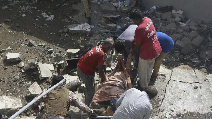 A firefighter tries to put out fire caused by plane crash in Karachi, Pakistan, Friday, May 22, 2020. An aviation official says a passenger plane belonging to state-run Pakistan International Airlines carrying more than 100 passengers and crew has crashed near the southern port city of Karachi. There were no immediate reports on the number of casualties. (AP Photo/Fareed Khan)