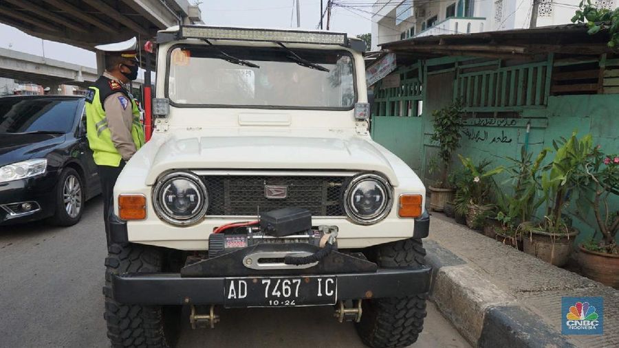 Petugas dishub dan polantas melakukan check point di Putaran jalan raya Kalimalang, Jakarta Timur, Jumat (22/5). Kepala UP Perparkiran DKI Jakarta Adji Kusambarto yang ditugaskan di check poin di putaran Jln Raya Kalimalang saat ditemui CNBC Indonesia mengatakan terkait dengan evaluasi sampai hari ini memang kita masih tahap sosialisasi kita tetap melakukan sosialisasi langsung pada pengguna jalan. Bagi mereka yang masuk dan keluar Jakarta harus menunjukkan SIKM bagi warga di luar Jabodetabek. Bagi warga yang tidak membawa SIKM nantinya akan diputar balikkan dan kembali ketempat asal mereka. Sampai sore ini ada sekitar 5 kendaraan roda empat yang disuruh putar balik dan 10 kendaraan roda dua. Sebagai besar yang disuruh putar balik diluar wilayah Jabodetabek. SIKM ini nantinya mulai berlaku mulai hari Senin. Seperti diketahui Pengendara yang melintas masuk atau keluar ibu kota di 12 titik checkpoint, wajib menunjukkan SIKM. Ketentuan ini sesuai Peraturan Gubernur Nomor 47 Tahun 2020 tentang Pembatasan Berpergian Keluar Masuk DKI Jakarta. SIKM diperuntukan bagi warga yang karena tugas dan pekerjaannya harus melakukan perjalanan dinas keluar dan/atau masuk wilayah DKI Jakarta atau Jabodetabek selama masa pandemi. (CNBC Indonesia/ Muhammad Sabki)