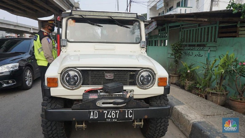 Petugas dishub dan polantas melakukan check point di Putaran jalan raya Kalimalang, Jakarta Timur, Jumat (22/5). Kepala UP Perparkiran DKI Jakarta Adji Kusambarto yang ditugaskan di check poin di putaran Jln Raya Kalimalang saat ditemui CNBC Indonesia mengatakan terkait dengan evaluasi sampai hari ini memang kita masih tahap sosialisasi kita tetap melakukan sosialisasi langsung pada pengguna jalan. Bagi mereka yang masuk dan keluar Jakarta harus menunjukkan SIKM bagi warga di luar Jabodetabek. Bagi warga yang tidak membawa SIKM nantinya akan diputar balikkan dan kembali ketempat asal mereka. Sampai sore ini ada sekitar 5 kendaraan roda empat yang disuruh putar balik dan 10 kendaraan roda dua. Sebagai besar yang disuruh putar balik diluar wilayah Jabodetabek. SIKM ini nantinya mulai berlaku mulai hari Senin. Seperti diketahui Pengendara yang melintas masuk atau keluar ibu kota di 12 titik checkpoint, wajib menunjukkan SIKM. Ketentuan ini sesuai Peraturan Gubernur Nomor 47 Tahun 2020 tentang Pembatasan Berpergian Keluar Masuk DKI Jakarta. SIKM diperuntukan bagi warga yang karena tugas dan pekerjaannya harus melakukan perjalanan dinas keluar dan/atau masuk wilayah DKI Jakarta atau Jabodetabek selama masa pandemi. (CNBC Indonesia/ Muhammad Sabki)