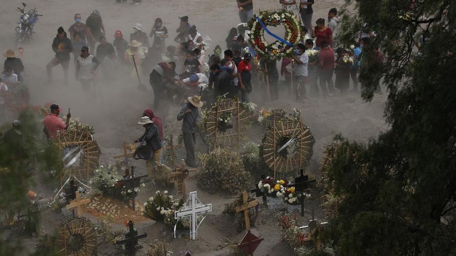 Workers wearing protective gear carry the plastic-wrapped coffin of a person who died from COVID-19 into the crematorium at San Cristobal Mausoleums in Ecatepec, Mexico State, part of the Mexico City metropolitan area, Thursday, May 21, 2020. When handling cases of confirmed or suspected COVID-19, crematorium workers wear protective suits, full-face respirators, and gloves, and maintain strict disinfection protocols. (AP Photo/Rebecca Blackwell)