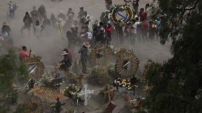 Workers wearing protective gear carry the plastic-wrapped coffin of a person who died from COVID-19 into the crematorium at San Cristobal Mausoleums in Ecatepec, Mexico State, part of the Mexico City metropolitan area, Thursday, May 21, 2020. When handling cases of confirmed or suspected COVID-19, crematorium workers wear protective suits, full-face respirators, and gloves, and maintain strict disinfection protocols. (AP Photo/Rebecca Blackwell)