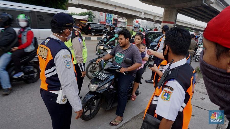 Petugas dishub dan polantas melakukan check point di Putaran jalan raya Kalimalang, Jakarta Timur, Jumat (22/5). Kepala UP Perparkiran DKI Jakarta Adji Kusambarto yang ditugaskan di check poin di putaran Jln Raya Kalimalang saat ditemui CNBC Indonesia mengatakan terkait dengan evaluasi sampai hari ini memang kita masih tahap sosialisasi kita tetap melakukan sosialisasi langsung pada pengguna jalan. Bagi mereka yang masuk dan keluar Jakarta harus menunjukkan SIKM bagi warga di luar Jabodetabek. Bagi warga yang tidak membawa SIKM nantinya akan diputar balikkan dan kembali ketempat asal mereka. Sampai sore ini ada sekitar 5 kendaraan roda empat yang disuruh putar balik dan 10 kendaraan roda dua. Sebagai besar yang disuruh putar balik diluar wilayah Jabodetabek. SIKM ini nantinya mulai berlaku mulai hari Senin. Seperti diketahui Pengendara yang melintas masuk atau keluar ibu kota di 12 titik checkpoint, wajib menunjukkan SIKM. Ketentuan ini sesuai Peraturan Gubernur Nomor 47 Tahun 2020 tentang Pembatasan Berpergian Keluar Masuk DKI Jakarta. SIKM diperuntukan bagi warga yang karena tugas dan pekerjaannya harus melakukan perjalanan dinas keluar dan/atau masuk wilayah DKI Jakarta atau Jabodetabek selama masa pandemi. (CNBC Indonesia/ Muhammad Sabki)