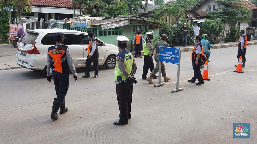 Petugas dishub dan polantas melakukan check point di Putaran jalan raya Kalimalang, Jakarta Timur, Jumat (22/5). Kepala UP Perparkiran DKI Jakarta Adji Kusambarto yang ditugaskan di check poin di putaran Jln Raya Kalimalang saat ditemui CNBC Indonesia mengatakan terkait dengan evaluasi sampai hari ini memang kita masih tahap sosialisasi kita tetap melakukan sosialisasi langsung pada pengguna jalan. Bagi mereka yang masuk dan keluar Jakarta harus menunjukkan SIKM bagi warga di luar Jabodetabek. Bagi warga yang tidak membawa SIKM nantinya akan diputar balikkan dan kembali ketempat asal mereka. Sampai sore ini ada sekitar 5 kendaraan roda empat yang disuruh putar balik dan 10 kendaraan roda dua. Sebagai besar yang disuruh putar balik diluar wilayah Jabodetabek. SIKM ini nantinya mulai berlaku mulai hari Senin. Seperti diketahui Pengendara yang melintas masuk atau keluar ibu kota di 12 titik checkpoint, wajib menunjukkan SIKM. Ketentuan ini sesuai Peraturan Gubernur Nomor 47 Tahun 2020 tentang Pembatasan Berpergian Keluar Masuk DKI Jakarta. SIKM diperuntukan bagi warga yang karena tugas dan pekerjaannya harus melakukan perjalanan dinas keluar dan/atau masuk wilayah DKI Jakarta atau Jabodetabek selama masa pandemi. (CNBC Indonesia/ Muhammad Sabki)