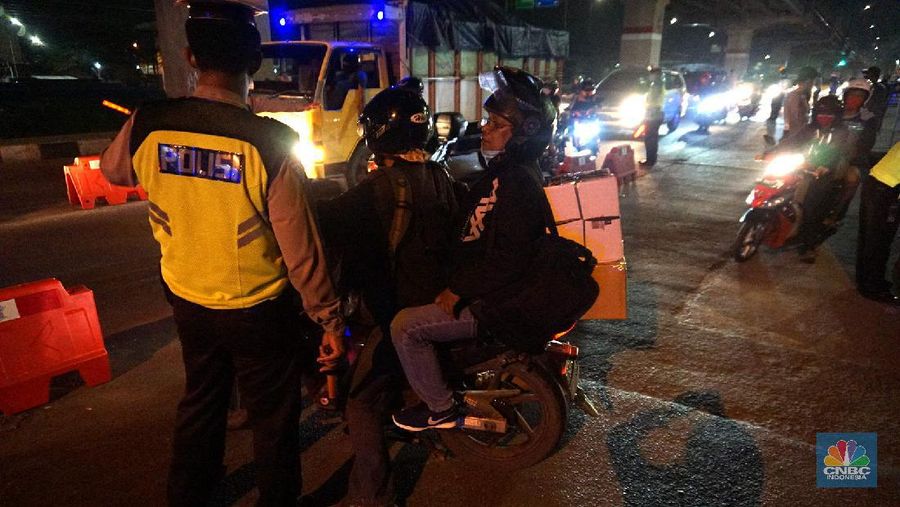 Petugas memeriksa kendaraan roda dua yang diduga untuk berpergian mudik di Jalan Raya Kalimalang, Jakarta Timur, Jumat (22/5). Dua hari jelang lebaran para pengendara motor masih ada yang nekat untuk pergi mudik. Petugas kepolisian dan Dishub memberhentikan motor yang memiliki muatan lebih. Pengendara motor diperiksa juga KTP asalnya. Jika ketahuan dari mereka mudik petugas menyuruh para pemudik motor untuk putar balik. Petugas kepolisian yang berjaga di check point jalan raya Kalimalang ini terus memantau, mengawasi dan melakukan pemeriksaan secara ketat agar pemudik yang berusaha keluar dari Jakarta bisa dihalau. Seperti diketahui Pengendara yang melintas masuk atau keluar ibu kota di 12 titik checkpoint, wajib menunjukkan SIKM. Ketentuan ini sesuai Peraturan Gubernur Nomor 47 Tahun 2020 tentang Pembatasan Berpergian Keluar Masuk DKI Jakarta. SIKM diperuntukan bagi warga yang karena tugas dan pekerjaannya harus melakukan perjalanan dinas keluar dan/atau masuk wilayah DKI Jakarta atau Jabodetabek selama masa pandemi. (²©²ÊÍøÕ¾/ Muhammad Sabki)