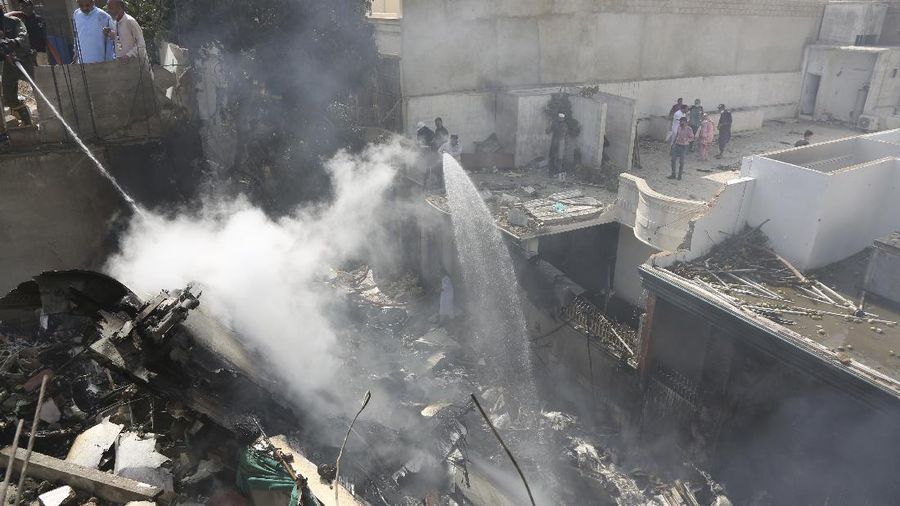 Fire brigade staff try to put out fire caused by plane crash in Karachi, Pakistan, Friday, May 22, 2020. An aviation official says a passenger plane belonging to state-run Pakistan International Airlines carrying more than 100 passengers and crew has crashed near the southern port city of Karachi. There were no immediate reports on the number of casualties. (AP Photo/Fareed Khan)