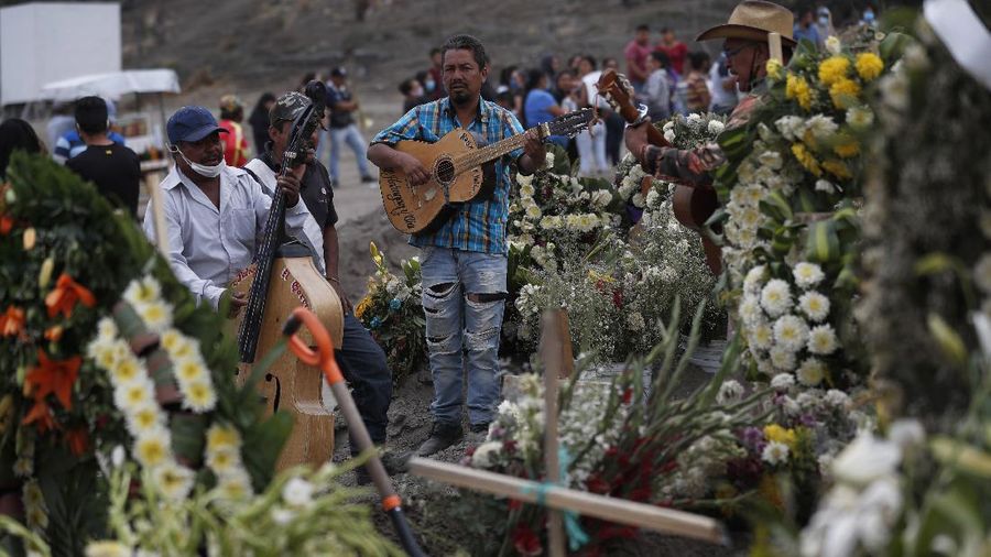 Workers wearing protective gear carry the plastic-wrapped coffin of a person who died from COVID-19 into the crematorium at San Cristobal Mausoleums in Ecatepec, Mexico State, part of the Mexico City metropolitan area, Thursday, May 21, 2020. When handling cases of confirmed or suspected COVID-19, crematorium workers wear protective suits, full-face respirators, and gloves, and maintain strict disinfection protocols. (AP Photo/Rebecca Blackwell)