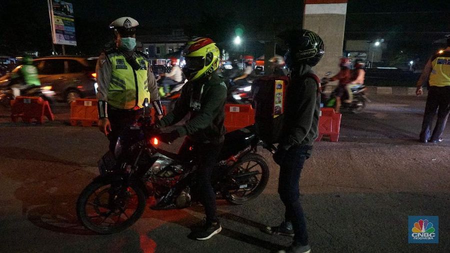Petugas memeriksa kendaraan roda dua yang diduga untuk berpergian mudik di Jalan Raya Kalimalang, Jakarta Timur, Jumat (22/5). Dua hari jelang lebaran para pengendara motor masih ada yang nekat untuk pergi mudik. Petugas kepolisian dan Dishub memberhentikan motor yang memiliki muatan lebih. Pengendara motor diperiksa juga KTP asalnya. Jika ketahuan dari mereka mudik petugas menyuruh para pemudik motor untuk putar balik. Petugas kepolisian yang berjaga di check point jalan raya Kalimalang ini terus memantau, mengawasi dan melakukan pemeriksaan secara ketat agar pemudik yang berusaha keluar dari Jakarta bisa dihalau. Seperti diketahui Pengendara yang melintas masuk atau keluar ibu kota di 12 titik checkpoint, wajib menunjukkan SIKM. Ketentuan ini sesuai Peraturan Gubernur Nomor 47 Tahun 2020 tentang Pembatasan Berpergian Keluar Masuk DKI Jakarta. SIKM diperuntukan bagi warga yang karena tugas dan pekerjaannya harus melakukan perjalanan dinas keluar dan/atau masuk wilayah DKI Jakarta atau Jabodetabek selama masa pandemi.  (CNBC Indonesia/ Muhammad Sabki)
