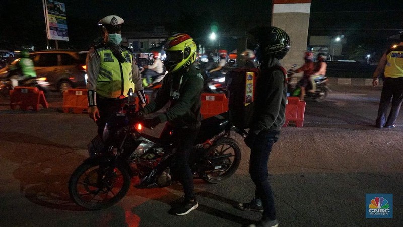 Petugas memeriksa kendaraan roda dua yang diduga untuk berpergian mudik di Jalan Raya Kalimalang, Jakarta Timur, Jumat (22/5). Dua hari jelang lebaran para pengendara motor masih ada yang nekat untuk pergi mudik. Petugas kepolisian dan Dishub memberhentikan motor yang memiliki muatan lebih. Pengendara motor diperiksa juga KTP asalnya. Jika ketahuan dari mereka mudik petugas menyuruh para pemudik motor untuk putar balik. Petugas kepolisian yang berjaga di check point jalan raya Kalimalang ini terus memantau, mengawasi dan melakukan pemeriksaan secara ketat agar pemudik yang berusaha keluar dari Jakarta bisa dihalau. Seperti diketahui Pengendara yang melintas masuk atau keluar ibu kota di 12 titik checkpoint, wajib menunjukkan SIKM. Ketentuan ini sesuai Peraturan Gubernur Nomor 47 Tahun 2020 tentang Pembatasan Berpergian Keluar Masuk DKI Jakarta. SIKM diperuntukan bagi warga yang karena tugas dan pekerjaannya harus melakukan perjalanan dinas keluar dan/atau masuk wilayah DKI Jakarta atau Jabodetabek selama masa pandemi.  (CNBC Indonesia/ Muhammad Sabki)