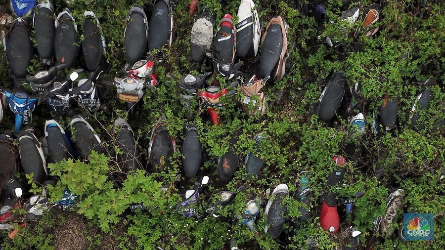 Sepeda motor terlihat diantara ilalang di tempat penampungan di Jalan Perjuangan, Teluk Pucung, Bekasi Utara, Jawa Barat, Indonesia, Kamis, 21 Mei 2020. Sepeda motor tersebut merupakan hasil razia dan korban kecelakaan lalu linta di wilayah Bekasi Kota. Motor tersebut menjadi rongsok hingga berkarat. Menurut data Korlantas Polri sepeda motor tercatat sebagai penyumbang besar angka kecelakaan lalu lintas dengan jumlah 35.980 pada triwulan II-2019, jumlah tersebut menurut dibanding triwulan I-2019 dengan jumlah 36.358.  (CNBC Indonesia/ Andrean Kristianto)