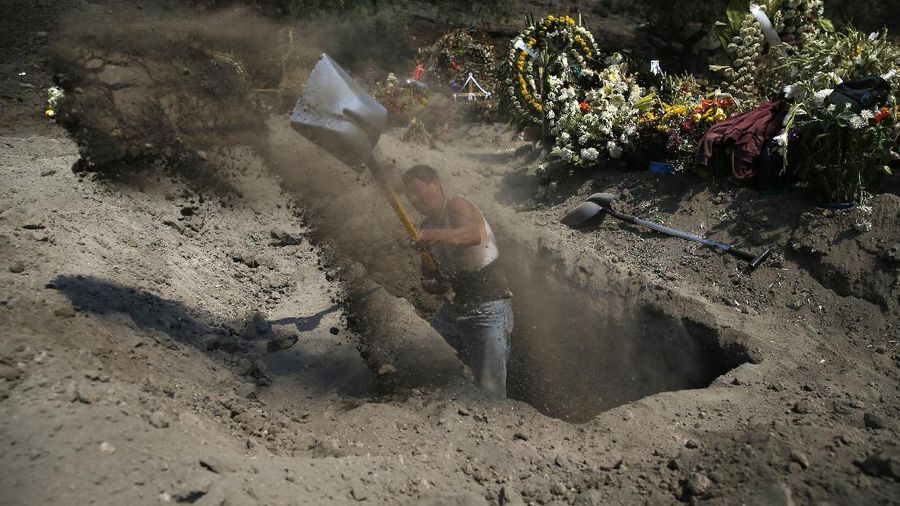 Workers wearing protective gear carry the plastic-wrapped coffin of a person who died from COVID-19 into the crematorium at San Cristobal Mausoleums in Ecatepec, Mexico State, part of the Mexico City metropolitan area, Thursday, May 21, 2020. When handling cases of confirmed or suspected COVID-19, crematorium workers wear protective suits, full-face respirators, and gloves, and maintain strict disinfection protocols. (AP Photo/Rebecca Blackwell)