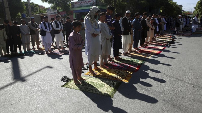 Worshippers wearing protective face masks offer Eid al-Fitr prayers outside a mosque to help prevent the spread of the coronavirus, in Tehran, Iran, Sunday, May 24, 2020. Muslims worldwide celebrate one of their biggest holidays under the long shadow of the coronavirus, with millions confined to their homes and others gripped by economic concerns during what is usually a festive time of shopping and celebration. In Iran, which has endured the deadliest outbreak in the Middle East, authorities have imposed few restrictions ahead of the holiday aside from cancelling mass prayers in Tehran traditionally led by Supreme Leader Ayatollah Ali Khamenei. (AP Photo/Vahid Salemi)