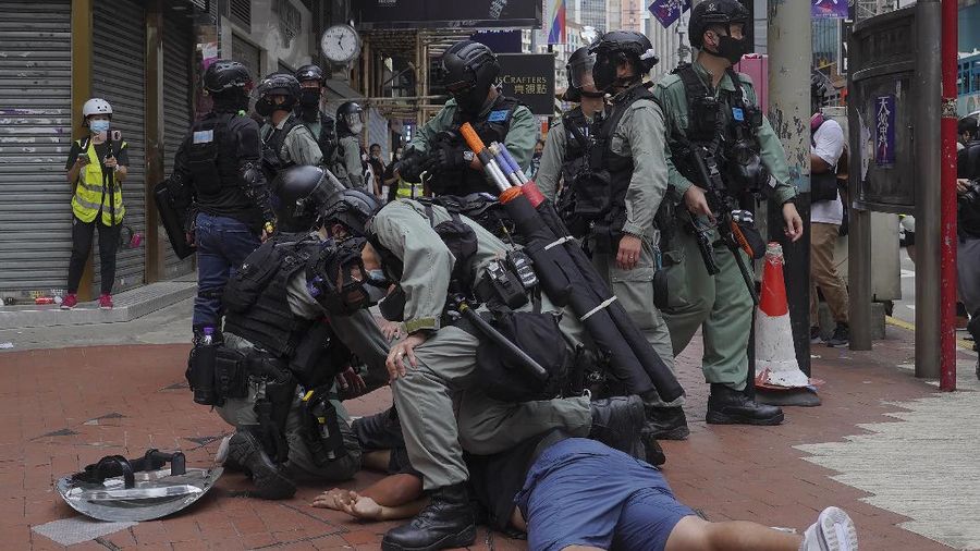 Riot police detain a protester during a demonstration against Beijing's national security legislation in Causeway Bay in Hong Kong, Sunday, May 24, 2020. Hong Kong police fired volleys of tear gas in a popular shopping district as hundreds took to the streets Sunday to march against China's proposed tough national security legislation for the city. (AP Photo/Vincent Yu)