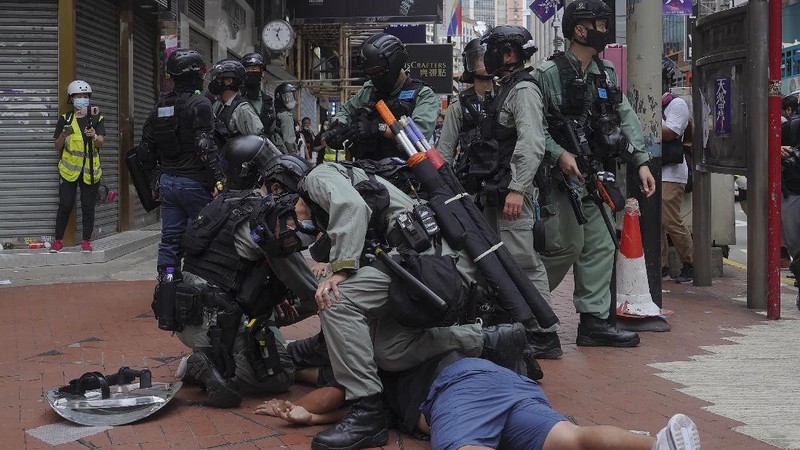 Riot police detain a protester during a demonstration against Beijing's national security legislation in Causeway Bay in Hong Kong, Sunday, May 24, 2020. Hong Kong police fired volleys of tear gas in a popular shopping district as hundreds took to the streets Sunday to march against China's proposed tough national security legislation for the city. (AP Photo/Vincent Yu)