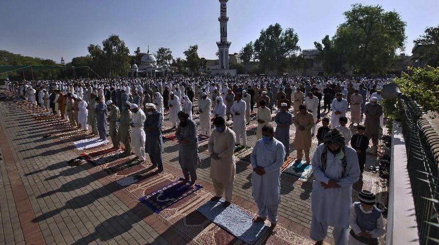 Worshippers wearing protective face masks offer Eid al-Fitr prayers outside a mosque to help prevent the spread of the coronavirus, in Tehran, Iran, Sunday, May 24, 2020. Muslims worldwide celebrate one of their biggest holidays under the long shadow of the coronavirus, with millions confined to their homes and others gripped by economic concerns during what is usually a festive time of shopping and celebration. In Iran, which has endured the deadliest outbreak in the Middle East, authorities have imposed few restrictions ahead of the holiday aside from cancelling mass prayers in Tehran traditionally led by Supreme Leader Ayatollah Ali Khamenei. (AP Photo/Vahid Salemi)