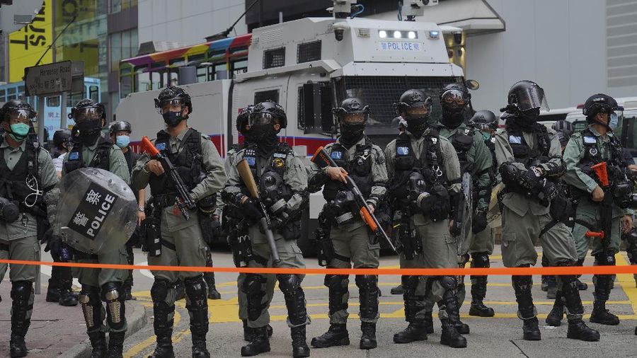 Riot police detain a protester during a demonstration against Beijing's national security legislation in Causeway Bay in Hong Kong, Sunday, May 24, 2020. Hong Kong police fired volleys of tear gas in a popular shopping district as hundreds took to the streets Sunday to march against China's proposed tough national security legislation for the city. (AP Photo/Vincent Yu)
