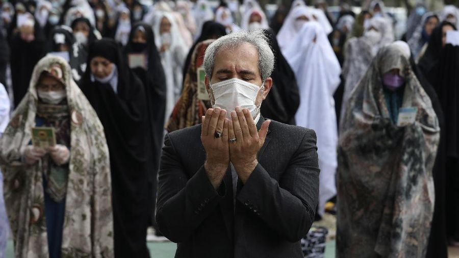Worshippers wearing protective face masks offer Eid al-Fitr prayers outside a mosque to help prevent the spread of the coronavirus, in Tehran, Iran, Sunday, May 24, 2020. Muslims worldwide celebrate one of their biggest holidays under the long shadow of the coronavirus, with millions confined to their homes and others gripped by economic concerns during what is usually a festive time of shopping and celebration. In Iran, which has endured the deadliest outbreak in the Middle East, authorities have imposed few restrictions ahead of the holiday aside from cancelling mass prayers in Tehran traditionally led by Supreme Leader Ayatollah Ali Khamenei. (AP Photo/Vahid Salemi)